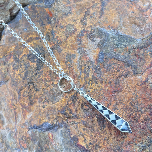 Silver necklace with a pendant on a stone surface