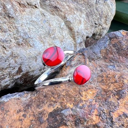 Silver rings with red stones on a stone surface