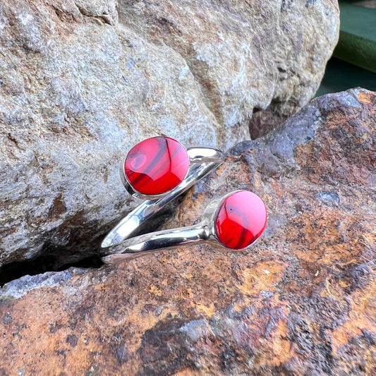 Silver rings with red stones on a stone surface