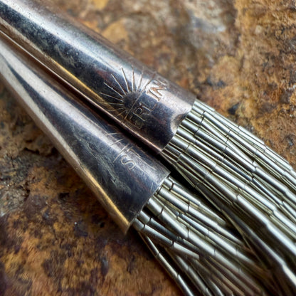 The end caps of the sterling silver multi strand necklace stamped "Sterling" with a sunrise detailing above the wording.