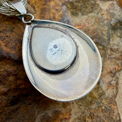 The back of a teardrop pendant, stamped "Sterling" And some other various hallmarks