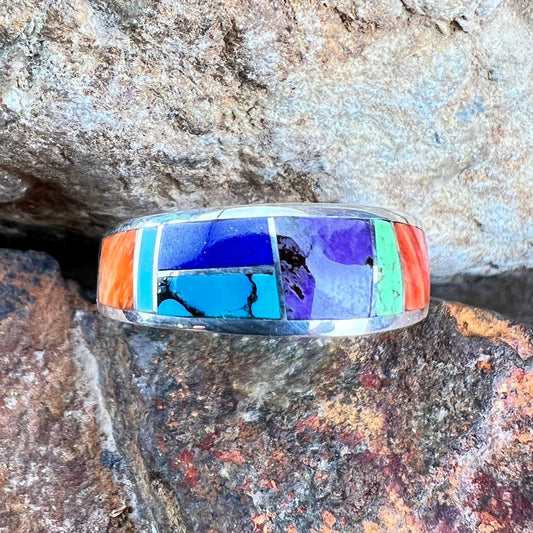 Multicolored inlay ring on a textured stone background