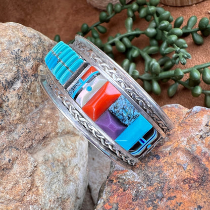 Multicolored stone cuff with silver band on a stone surface
