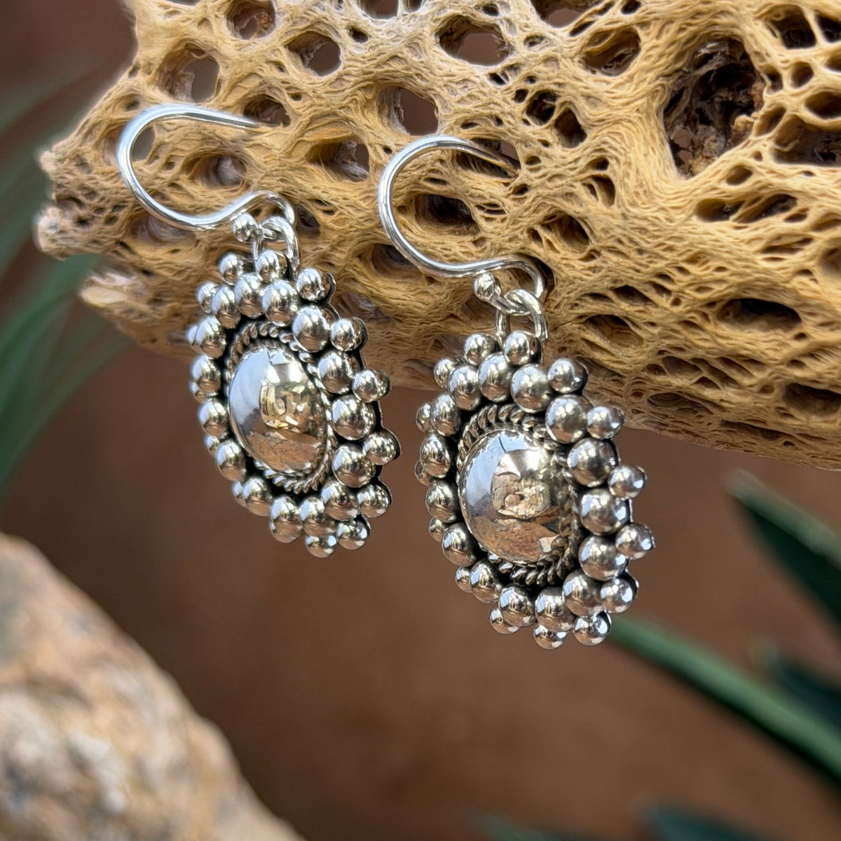 Artie Yellowhorse beaded dome earrings hanging from silver ear wires