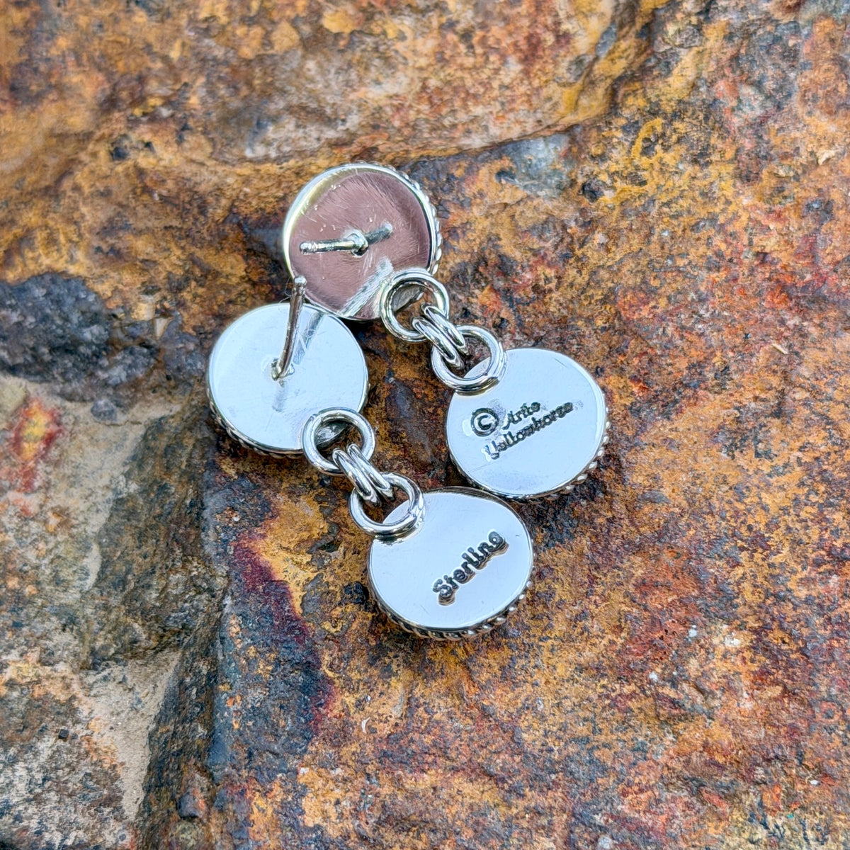 Backs of Artie Yellowhorse post earrings showing artist hallmark and Sterling stamp