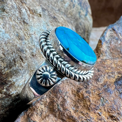 Silver ring with a blue stone on a rocky background