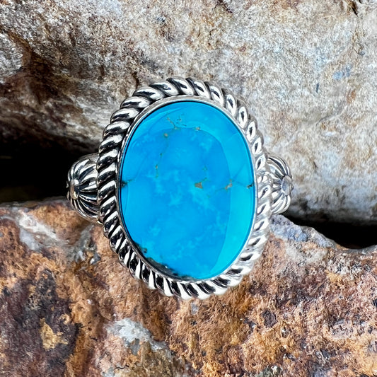 Silver ring with a blue stone on a rocky background