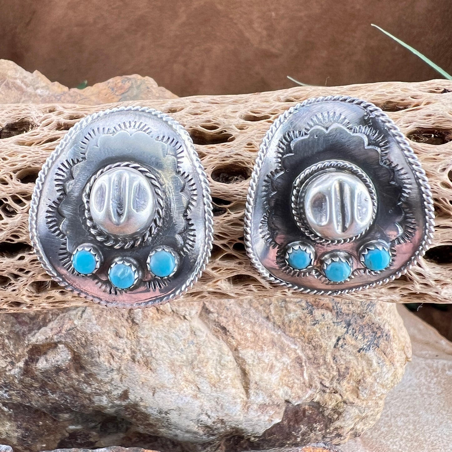 Silver earrings with turquoise stones on a natural stone background