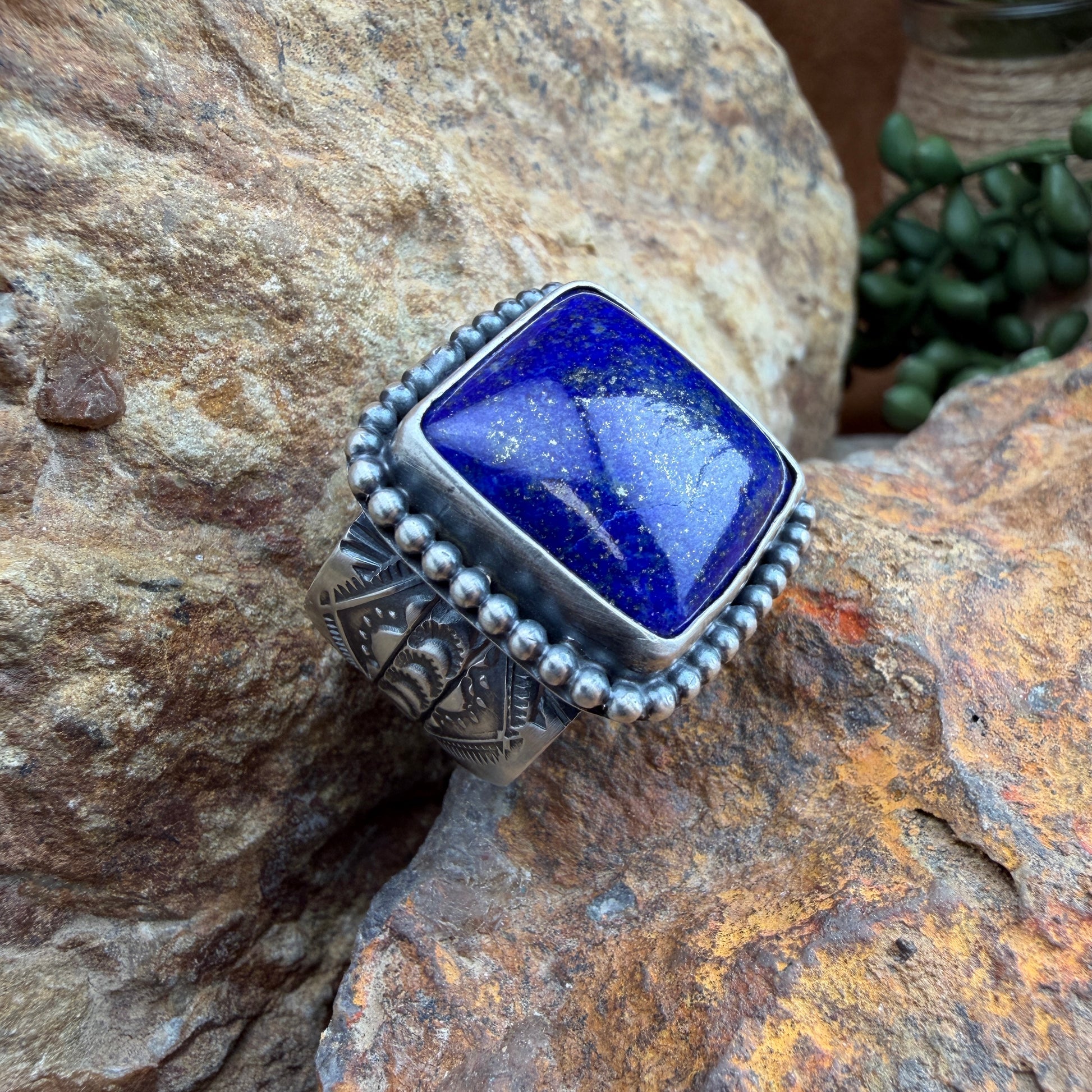 Silver ring with a blue stone on a rock