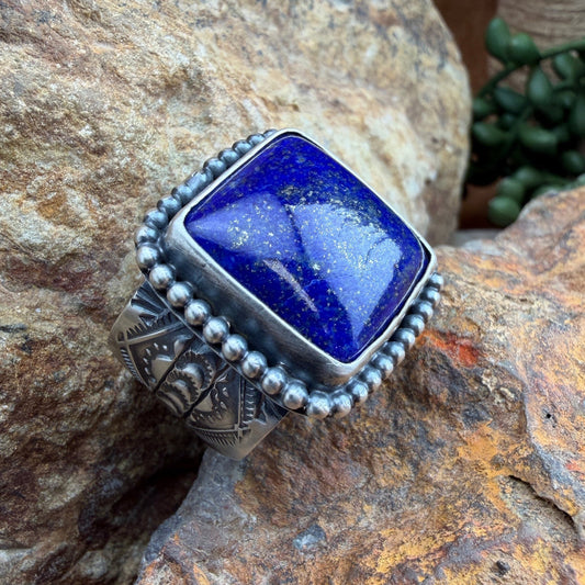 Silver ring with a blue stone on a rock
