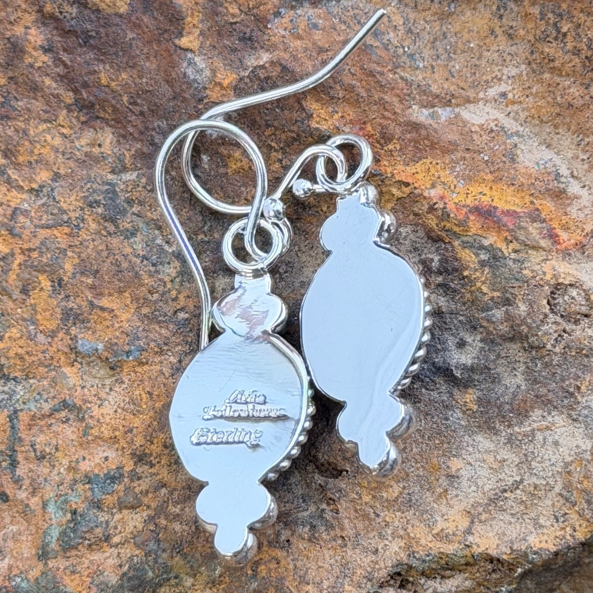 Back of Artie Yellowhorse sterling silver dangle earrings showing the artist hallmark