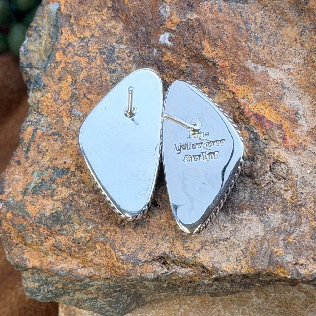 Angled pair of shield-shaped blue lapis earrings with pyrite flecks and twisted-rope sterling silver borders