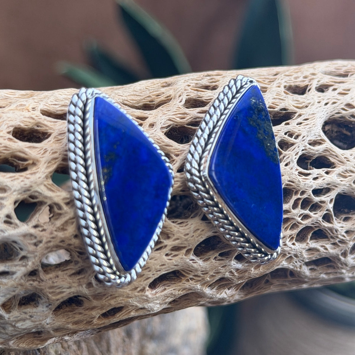 Front view of shield-shaped lapis lazuli earrings with pyrite flecks by Artie Yellowhorse