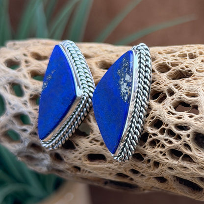 Alternate angled view of blue lapis and pyrite post earrings with rope-edge silverwork