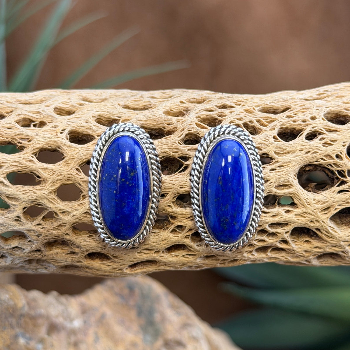 Backs of Artie Yellowhorse sterling silver lapis lazuli post earrings showing the artist hallmark