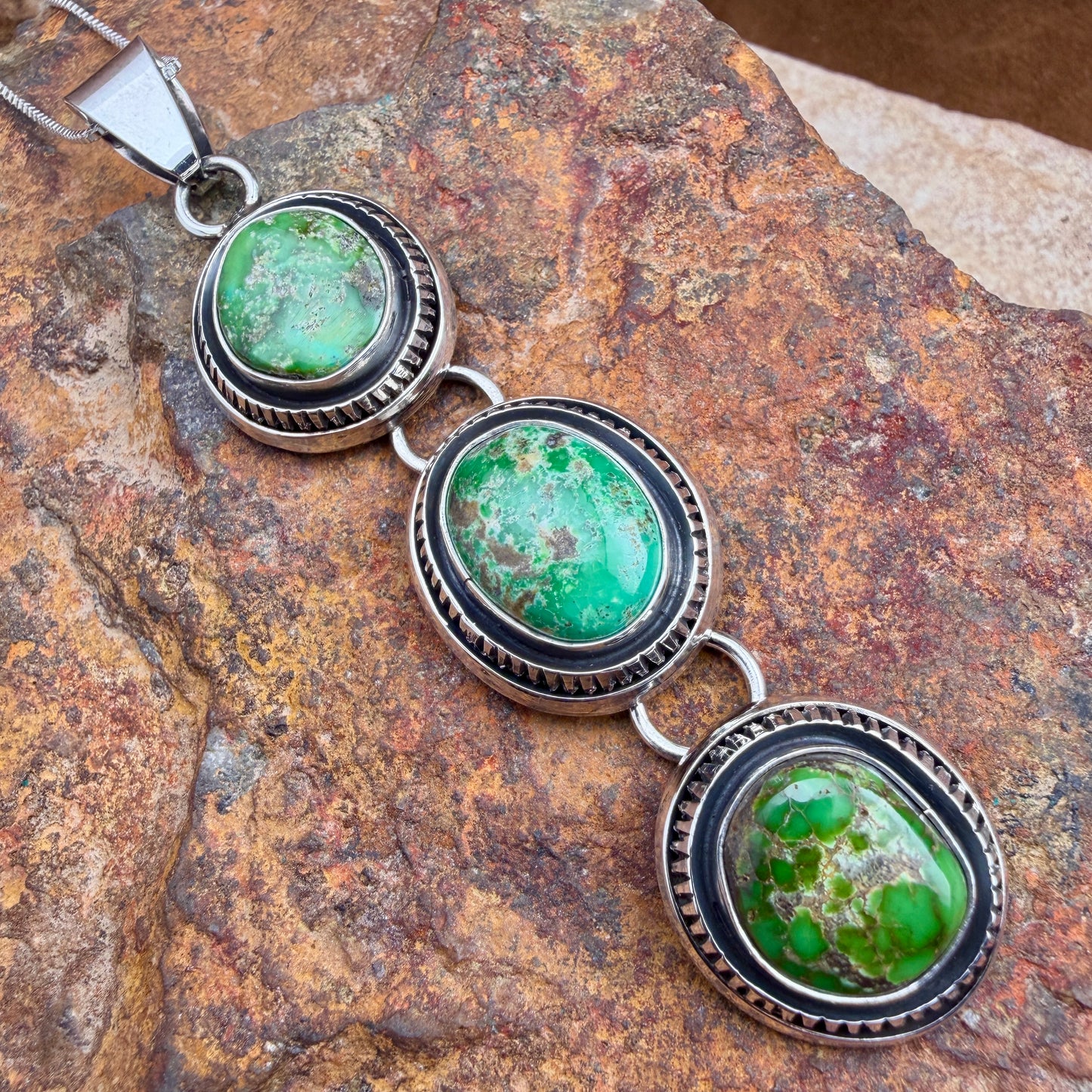 Three green stoned pendant, each separated by a swivel.