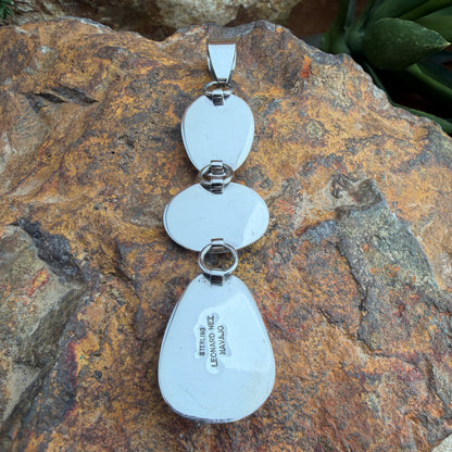Back of a silver necklace pendant with stamping on it; LEONARD NEZ, NAVAJO, STERLING
