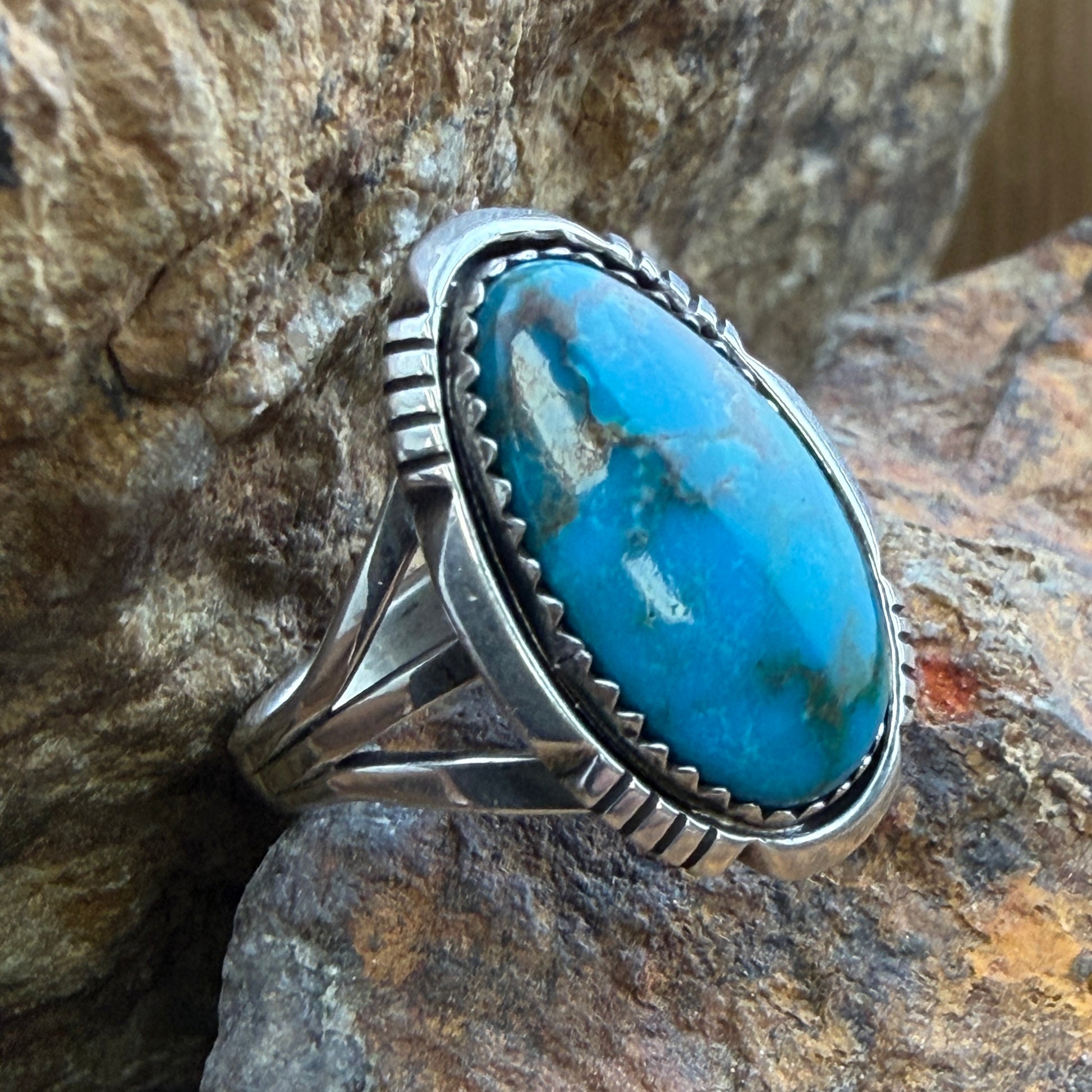 Lone Mountain Turquoise Ring by Ray Coriz - side view on rock showing split shank and hand-stamped arrow shoulder details