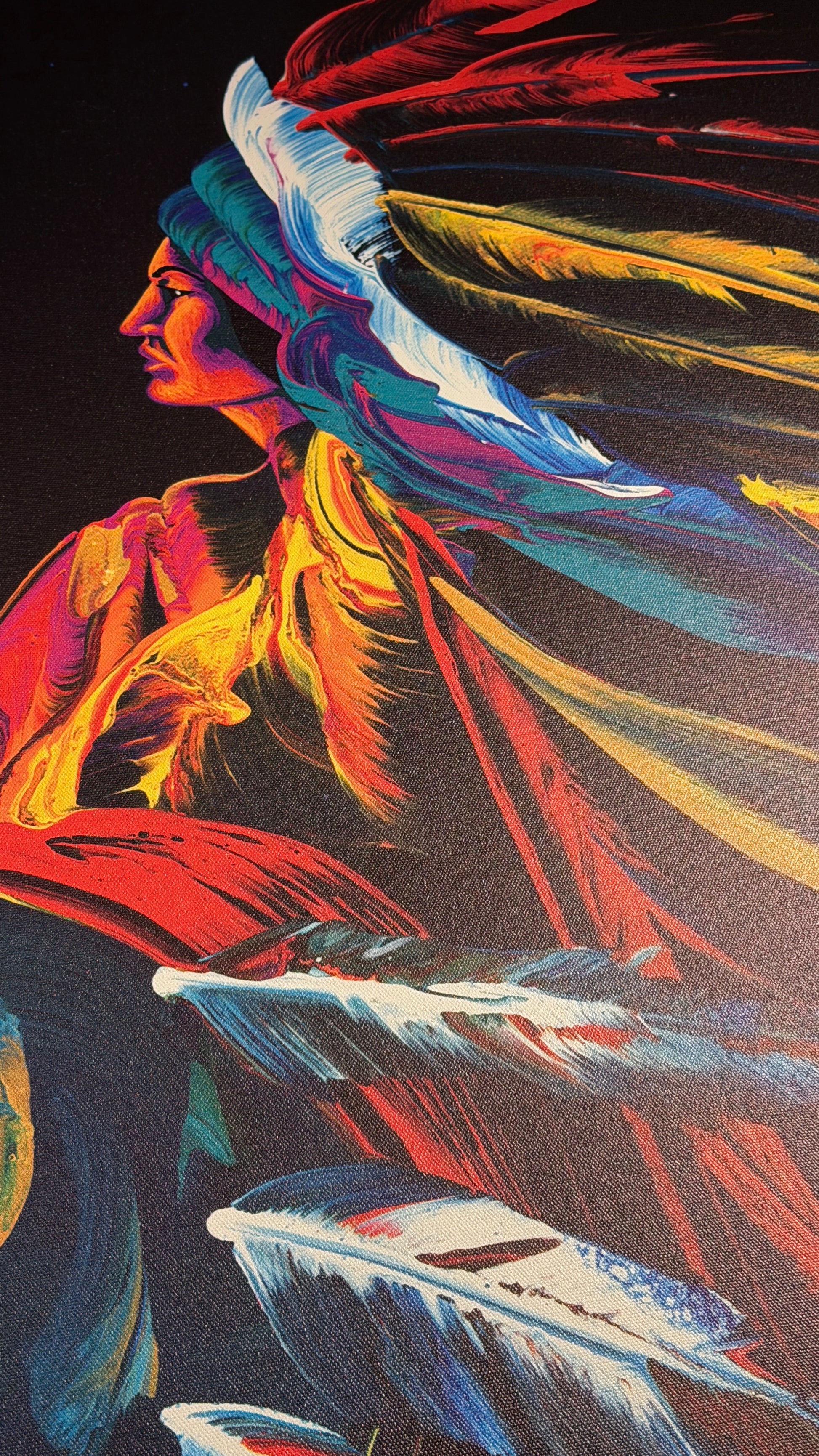 Vibrant, colorful art print depicting a Native American profile wearing a feathered headdress, rendered in bold strokes of red, yellow, blue, and white against a dark background.