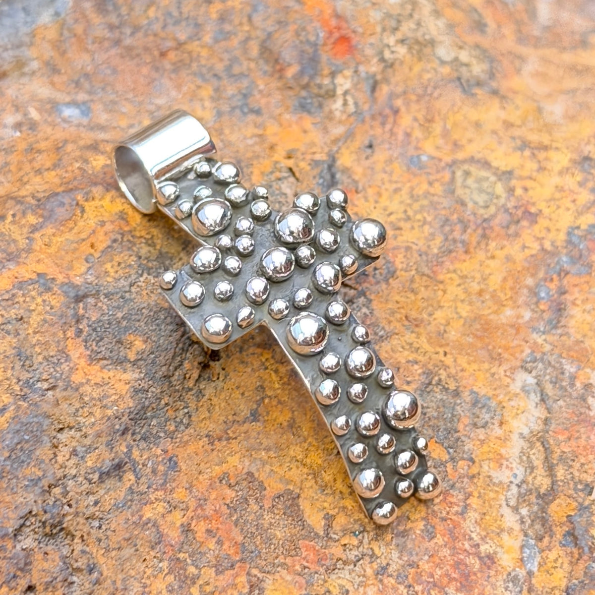 Million Drops curved cross pendant by Akee Douglas, front view