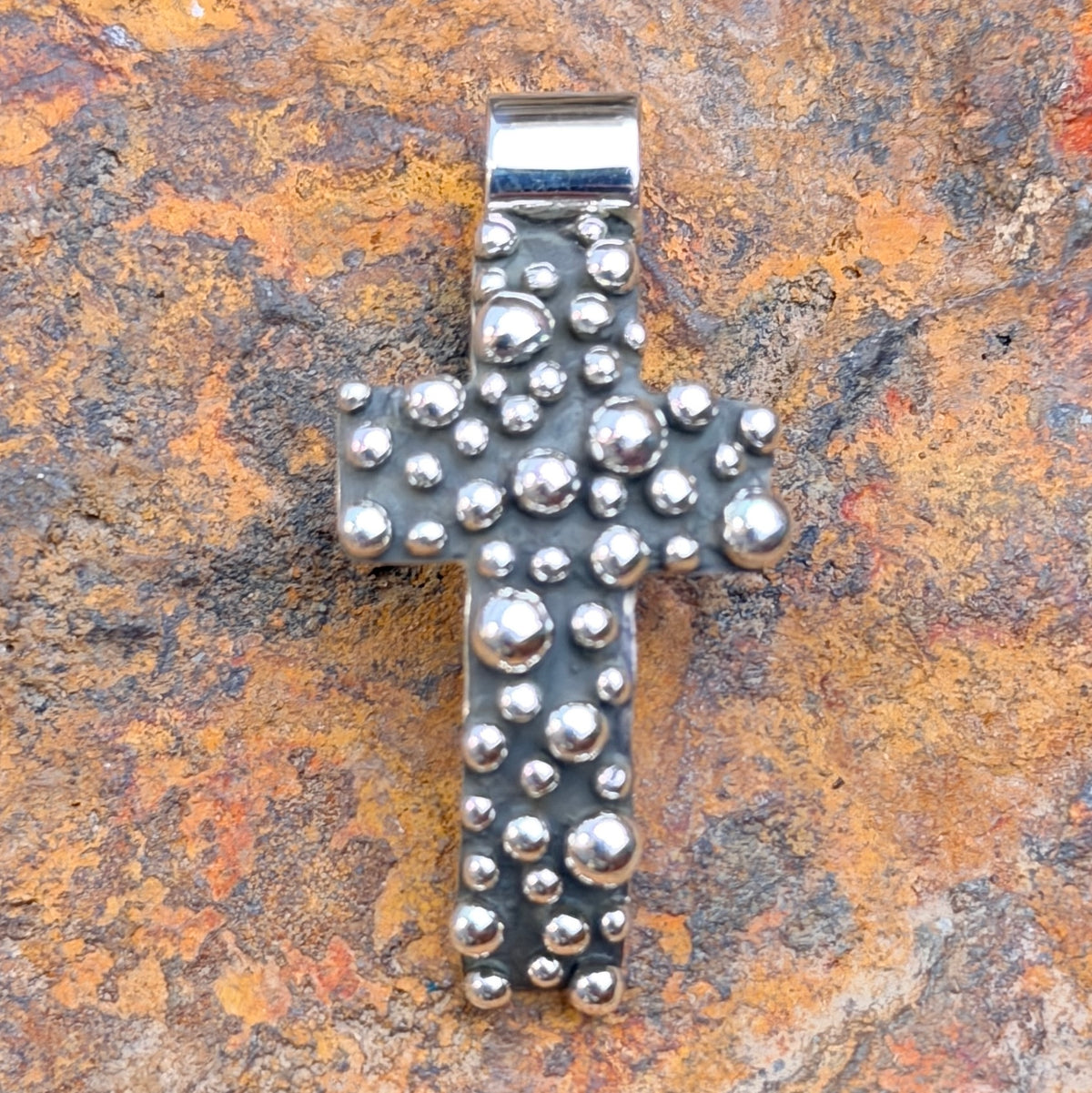 Polished silver drops and broad bail on Akee Douglas cross pendant