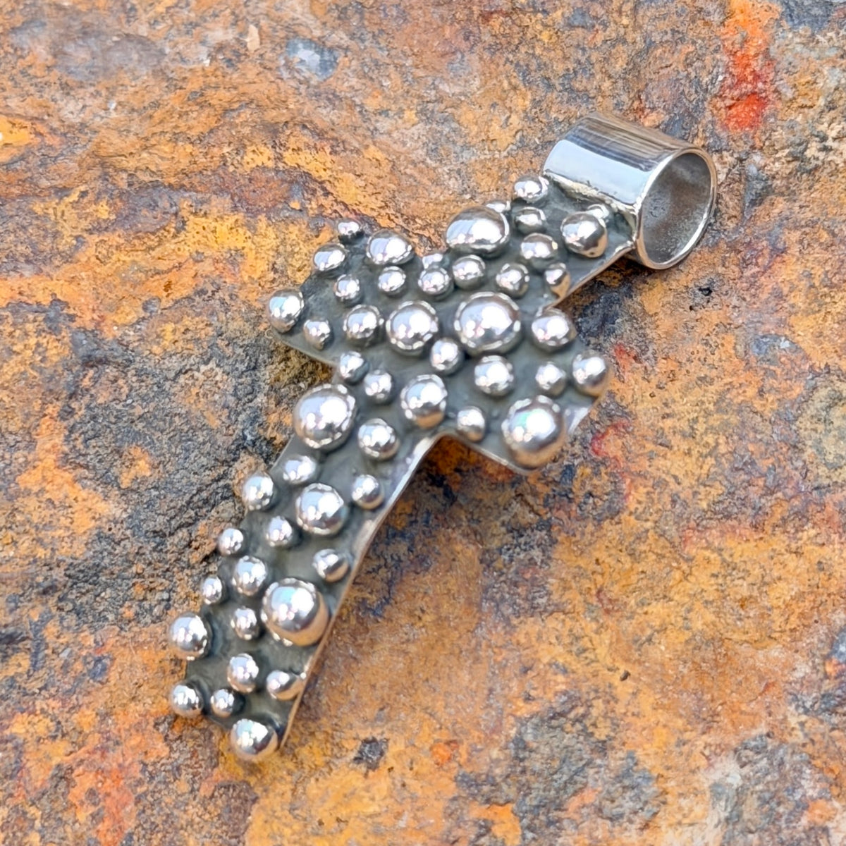Reverse of cross pendant showing A. Douglas hallmark and sterling stamp