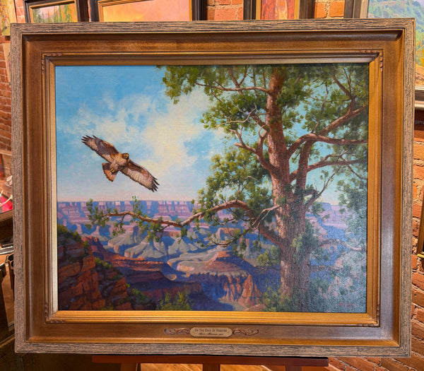 Framed painting of a landscape with a bird flying over a tree and canyon.