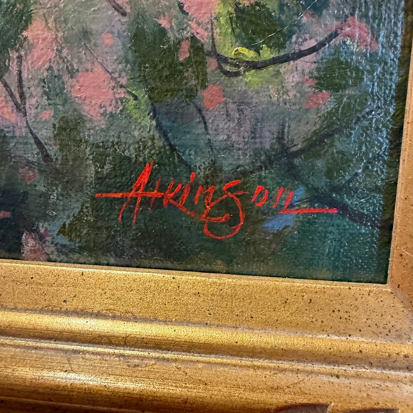 Artistic signature on a painting with a gold frame