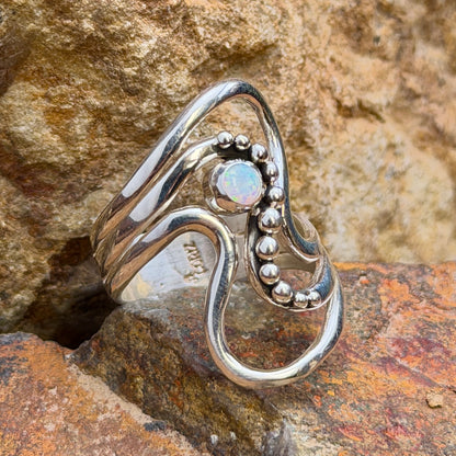 Front view of opal wave ring by Ray Coriz with rounded silver accents