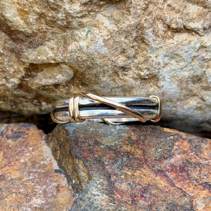 Sterling silver ring with gold-tone diagonal wrap, angled view