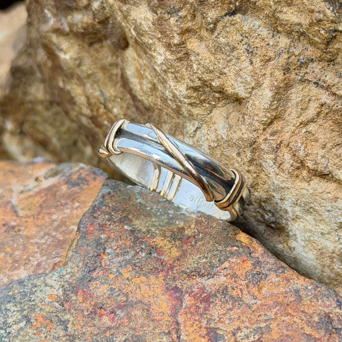 Side view of sterling silver ring with gold-tone crossover accents