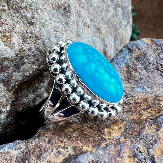 Silver ring with a blue stone on a rocky background