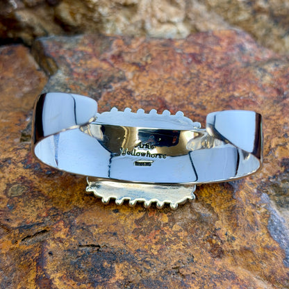 Rosarita Statement Cuff Bracelet by Artie Yellowhorse hallmark on a rocky surface,