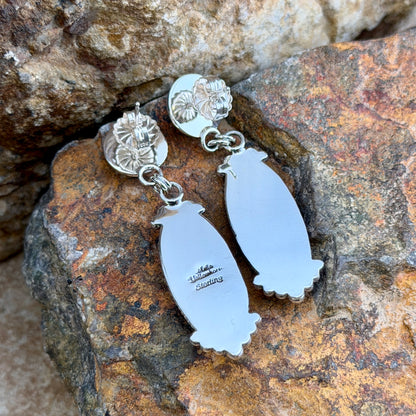 Rosarita Post Drop Earrings by Artie Yellowhorse, hallmark on a rocky surface