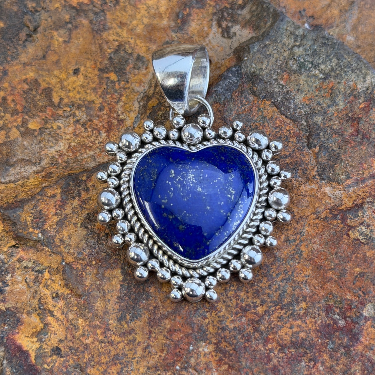 Royal Lapis heart pendant surrounded by a rope border and silver beads. 
