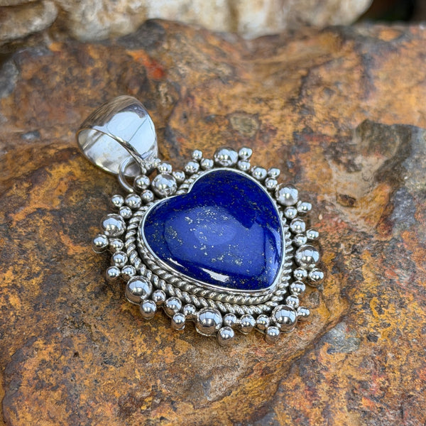 Royal Lapis heart pendant surrounded by a rope border and silver beads. 