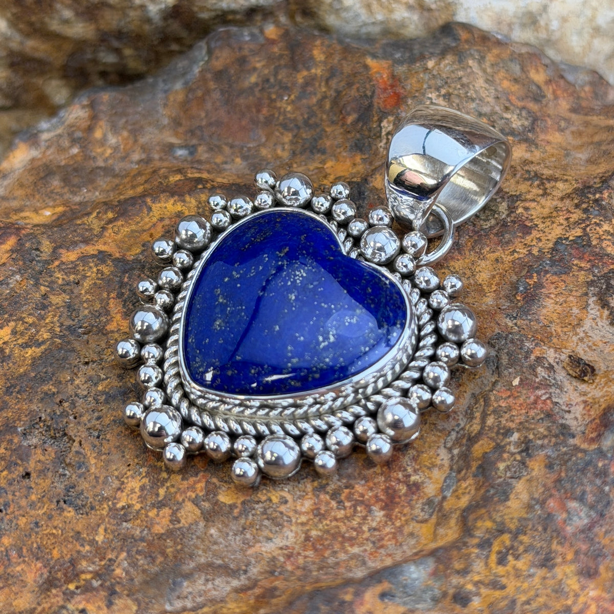 Royal Lapis heart pendant surrounded by a rope border and silver beads. 