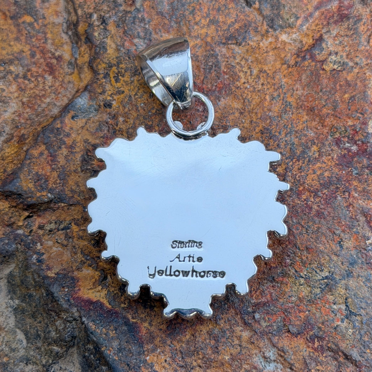 Royal Lapis heart pendant surrounded by a rope border and silver beads. back of the pendant displaying stamping " Artie Yellowhorse" "Sterling"