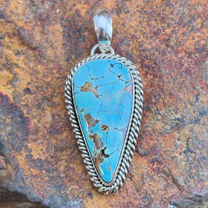 Front of blue Royston turquoise teardrop pendant with silver rope border