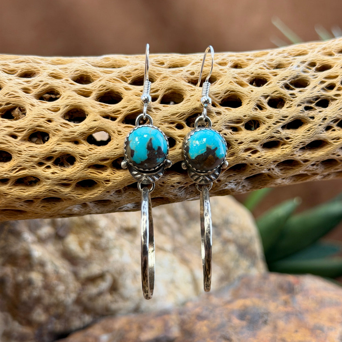 round blue toned royston turquoise cabochons with hoops that dangle from them. made by mary tso