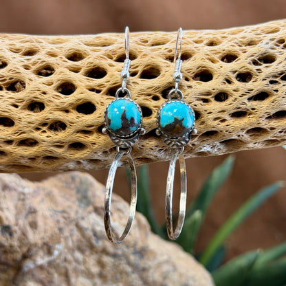 round blue toned royston turquoise cabochons with hoops that dangle from them. made by mary tso