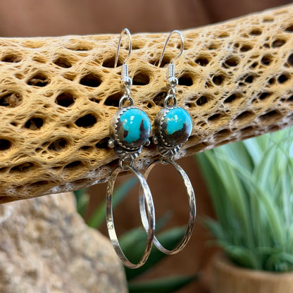 round blue toned royston turquoise cabochons with hoops that dangle from them. made by mary tso