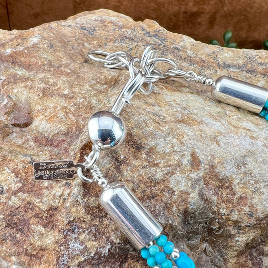 Silver and turquoise beaded necklace on a stone surface