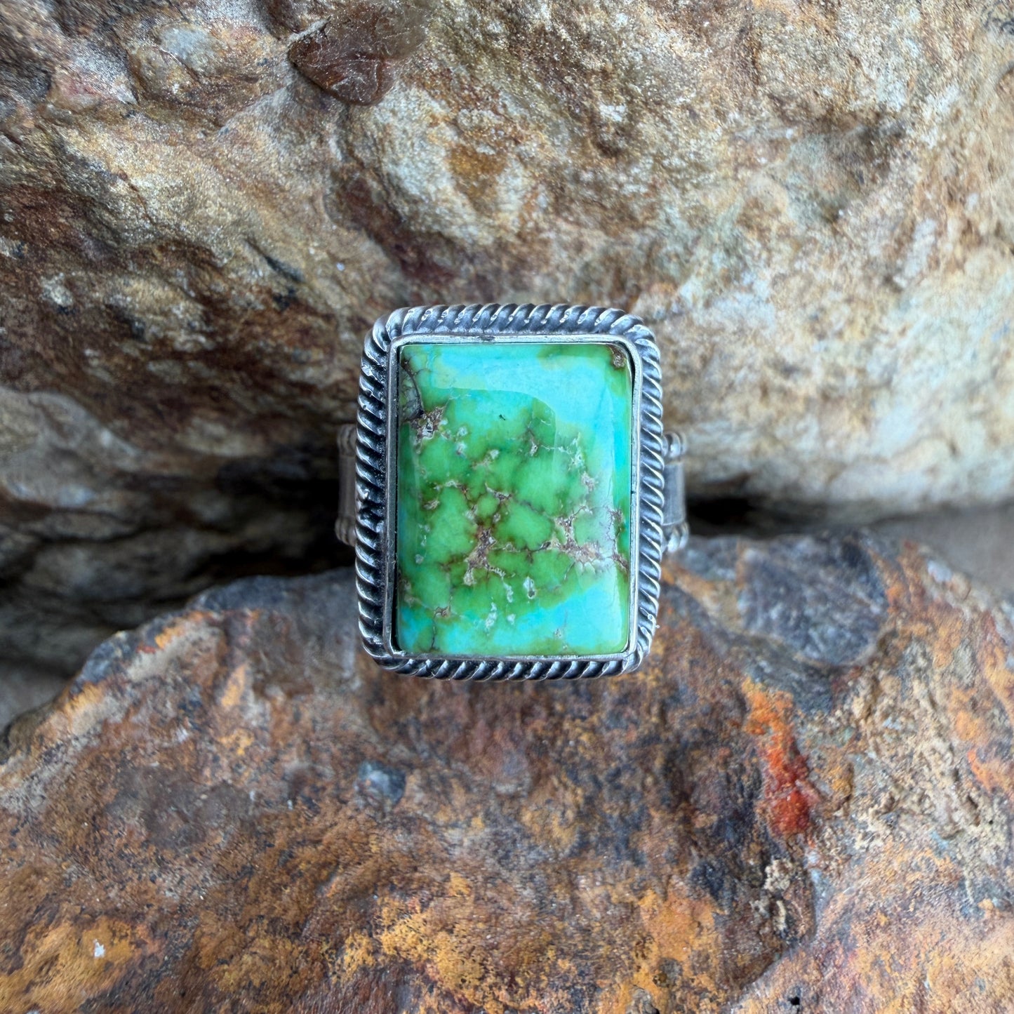 Turquoise stone ring on a textured rock background