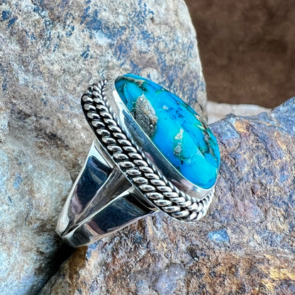 Silver ring with a blue stone on a rocky surface