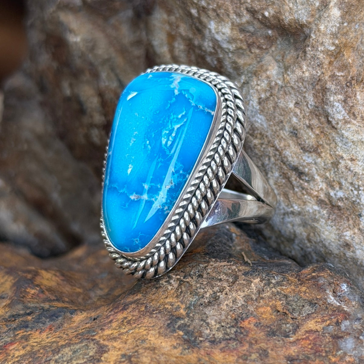 Angled view of Sonoran Rose turquoise ring with silver rope borders