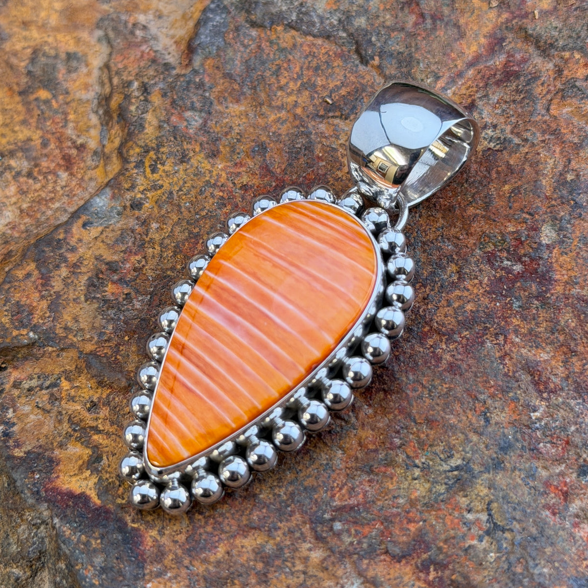 Spiny Oyster Sterling Pendant by Artie Yellowhorse, angled view