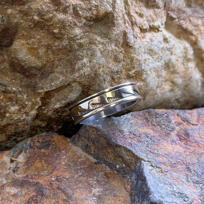 A silver band ring geometric wave motiff overlay in gold
