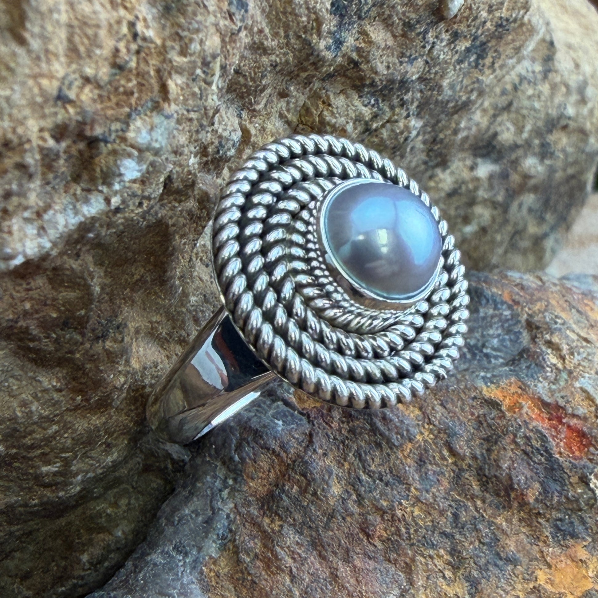 Sterling Silver ring with a centralized Gray Freshwater Pearl. Around the pearl is a coiled rope texture.