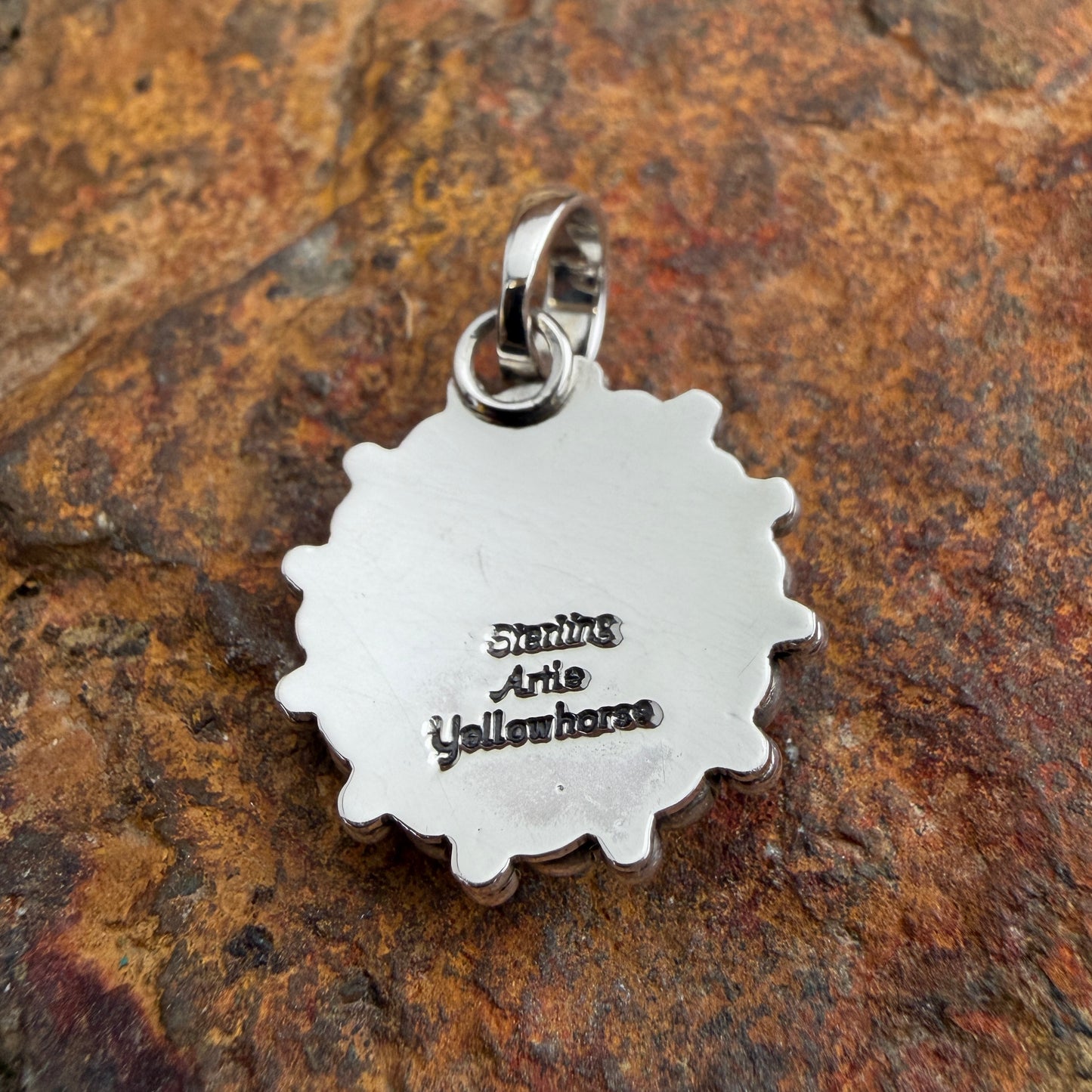 A polished domed sterling silver Pendant, its center is completely encircled by two concentric rows of bold and luminous all-silver pendant handcrafted by Navajo artist Artie Yellowhorse, showcasing her signature Million Drop technique. and-soldered graduated sterling silver shot beads, radiating outward in a striking sunburst halo.